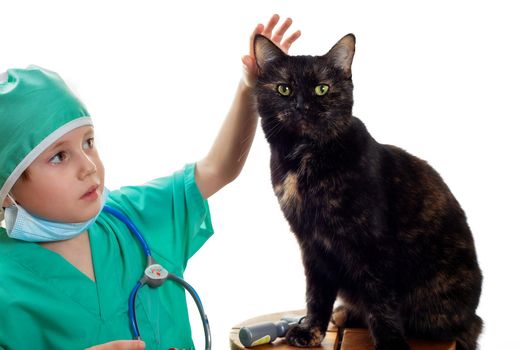Girl in green medical surgical suit and protective medical mask plays veterinarian with domestic black cat Isolated on white