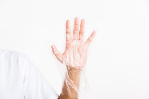 Woman hand wearing single use protect disposable transparent plastic glove, studio shot isolated on white background