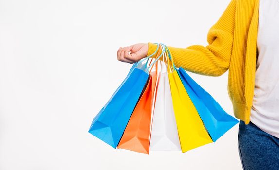 Happy woman hand she wears yellow shirt holding shopping bags multicolor, young female hold many packets within arms isolated on white background, Black Friday sale concept