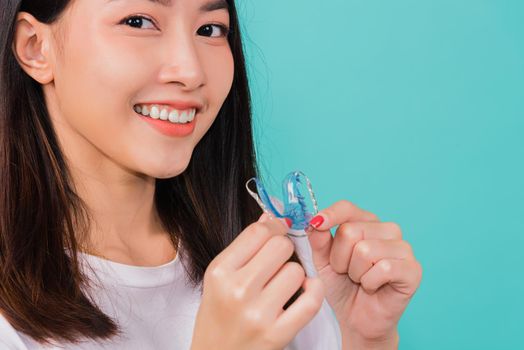 Teeth retaining tools after removable braces, Portrait young Asian beautiful woman smiling holding silicone orthodontic retainers for teeth, Orthodontics dental healthy care concept