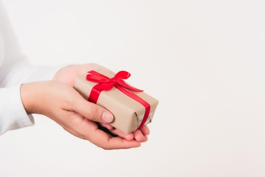 Valentine's Day. Woman beauty hands holding small gift package box present wrapped paper with ribbon isolated on white background, Birthday, New year, Christmas, holiday background concept