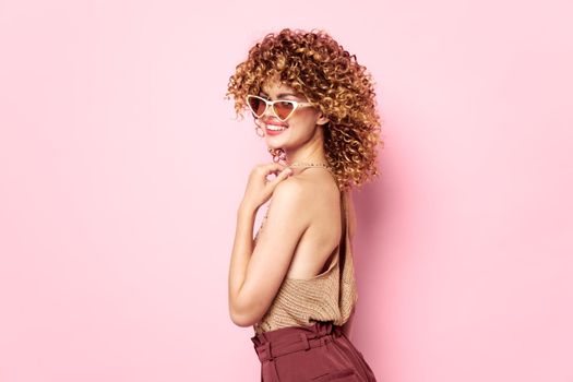 Attractive woman Curly hair smile sunglasses pink background fashion clothes cropped view