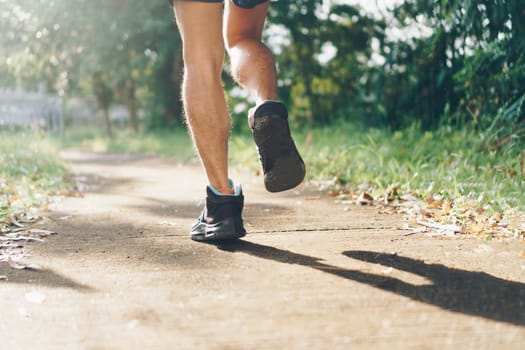 Woman wear running shoe on to walking and running on nature green background.Health exercise concept.