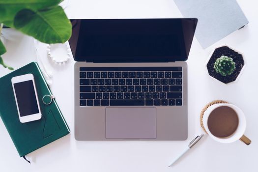 Top view of modern laptop or notebook with phone to work. Office desktop on table background.