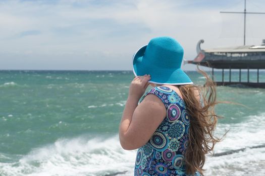 Yalta, Crimea. The girl in the blue hat on the blurred background of the seascape.