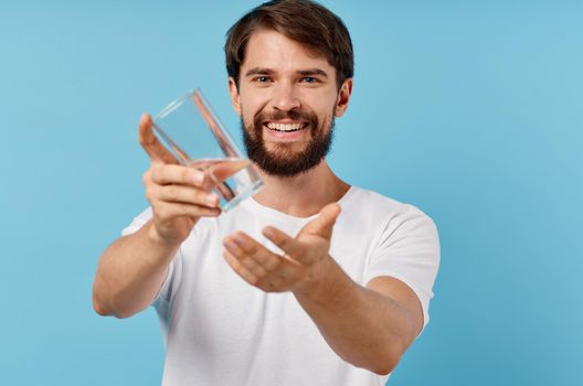 happy man with glass of water on blue background drink lifestyle. High quality photo