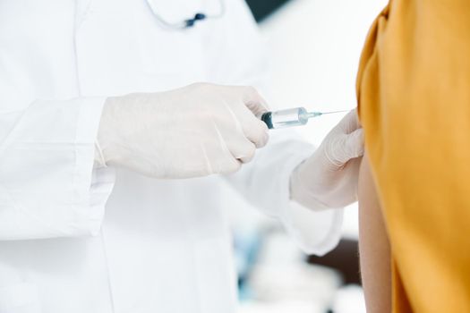 doctor giving injection to patient's shoulder close-up cropped view syringe epidemic health. High quality photo