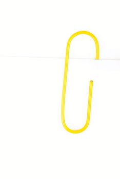 yellow paper clip on a white background