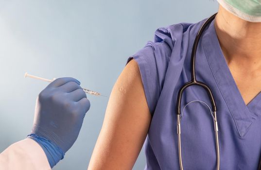 Doctor doing vaccine injection to Medical personnel in hospital.