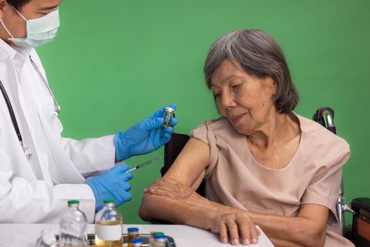 Chroma key, nurse doing vaccine injection to senior woman.