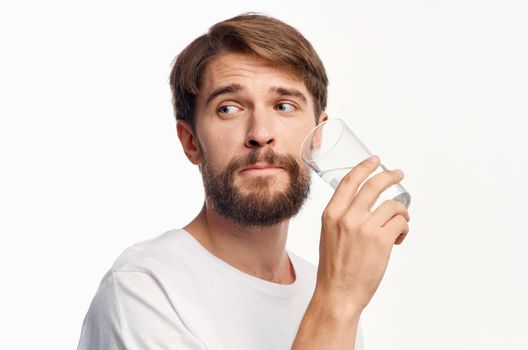 handsome guy with a glass of water on a white background t-shirt cropped view Model. High quality photo