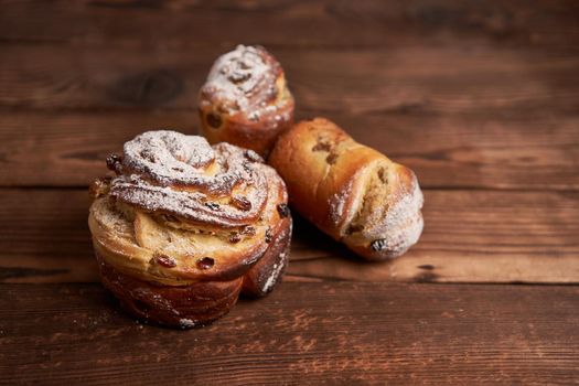 Traditional easter cake Kraffin stands on wooden table against a dark background. Spring holiday bread with copy space