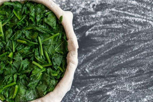 raw spinach pie preparation Standing wooden table background Copy space for text