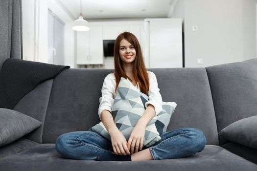 woman sitting on the couch in her free time with a pillow in her hands rest. High quality photo