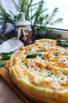 Homemade baked lasagna with crispy crust on a wooden cutting board close up