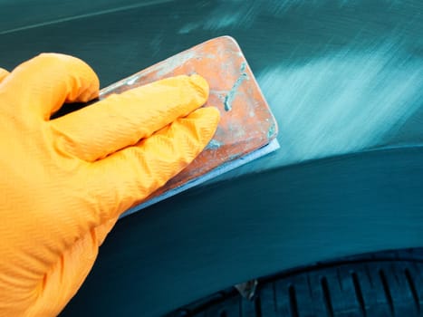 the process of treating the soil with an abrasive material manually. manual repair of car paintwork.