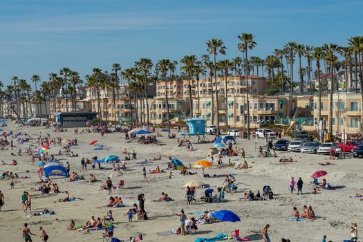People on the beach enjoying beautiful summer day at Oceanside beach in San Diego, California. 