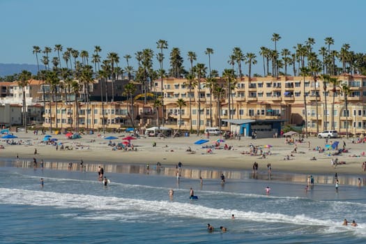 People on the beach enjoying beautiful summer day at Oceanside beach in San Diego, California. 