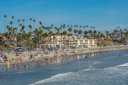 People on the beach enjoying beautiful summer day at Oceanside beach in San Diego, California. 