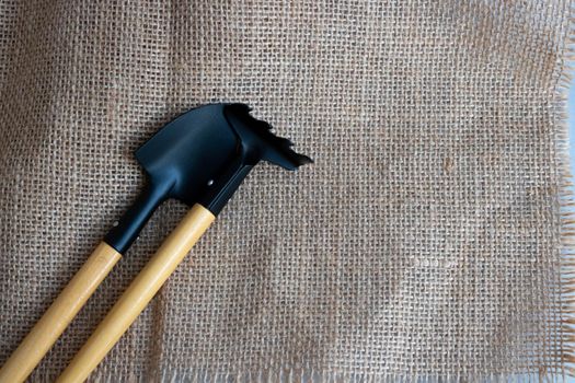 The garden tool a shovel, a rake with sackcloth background.
