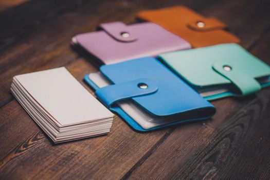 bright business card holders and a pack of white paper on a wooden background close-up. High quality photo