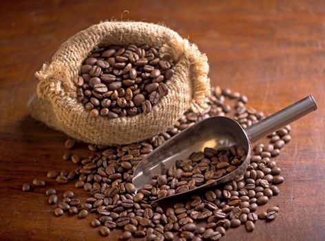 cup of coffee and coffee beans in a sack on dark background