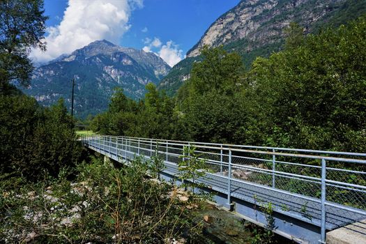 Blue steel bridge over the Verzasca river in the Valle Verzasca, Ticino, Switzerland