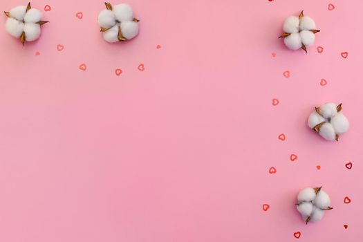 Congratulations on Valentine's Day. Cotton flowers and gold hearts on a pink background. Mock up. Flat ley