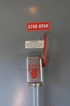 Closeup of emergency brake lever on brown wall in train