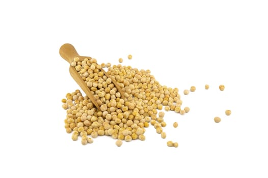 Dried peas spilling from a wooden scoop isolated on a white background