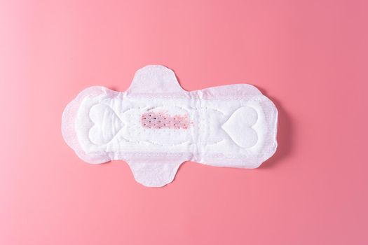 Used Sanitary pad with little amount of blood, Sanitary napkin on pink background. Menstruation, Feminine hygiene, top view.