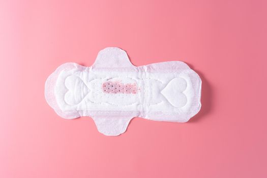 Used Sanitary pad with little amount of blood, Sanitary napkin on pink background. Menstruation, Feminine hygiene, top view.