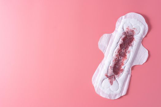 Used Sanitary pad with full amount of blood, Sanitary napkin on pink background. Menstruation, Feminine hygiene, top view.