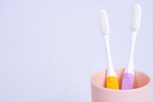 Closeup toothbrush in the glass isolated grey background. Copy space for text.