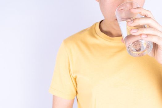 Man drinking water isolated grey background. Clean drinking water in clear glass.