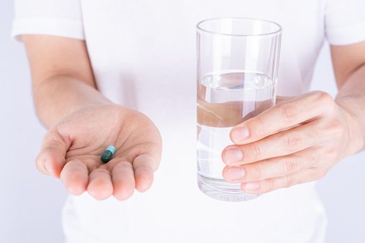 Close up hands holding glass of water and pill drugs. Healthcare and medical pharmacy concept.