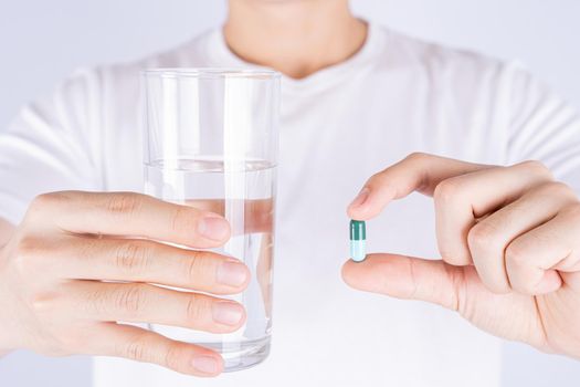 Close up hands holding glass of water and pill drugs. Healthcare and medical pharmacy concept.