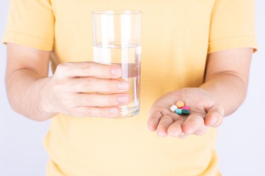 Close up hands holding glass of water and pill drugs. Healthcare and medical pharmacy concept.