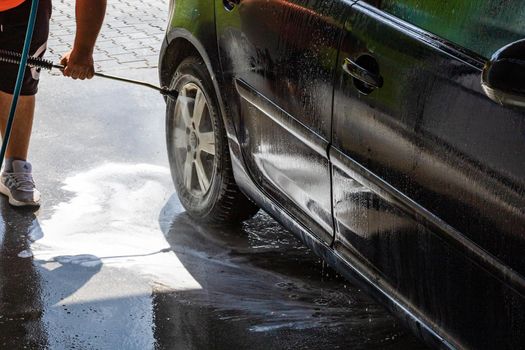 Washing and cleaning car in self service car wash station. Car washing using high pressure water in Bucharest, Romania, 2021