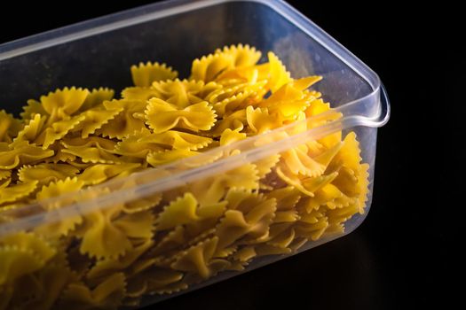 Close up of dry uncooked farfalle pasta isolated.