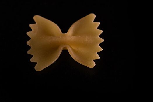 Close up of dry uncooked farfalle pasta isolated.