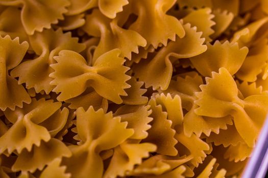 Close up of dry uncooked farfalle pasta isolated.