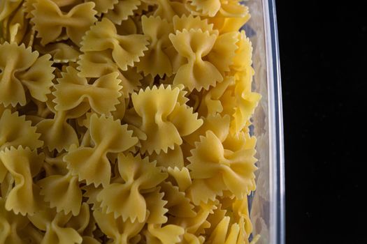 Close up of dry uncooked farfalle pasta isolated.