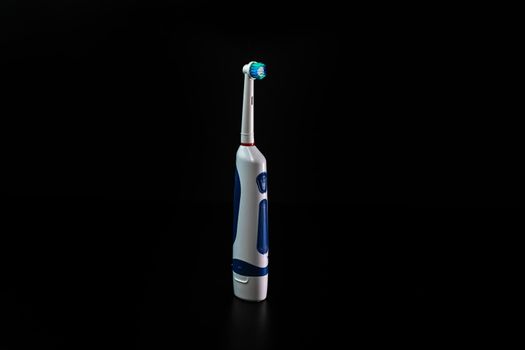 Close up of electric toothbrush isolated on black background.