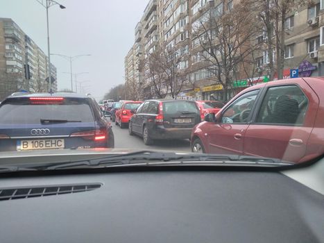 Road view through car windshield, cars on road in traffic in Bucharest, Romania, 2021