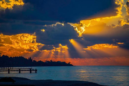 Seascape with a bright sunset and rays through the clouds.