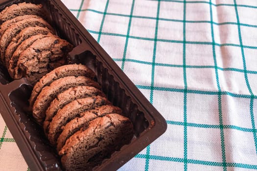 Chocolate cookies in packaging on cloth background.