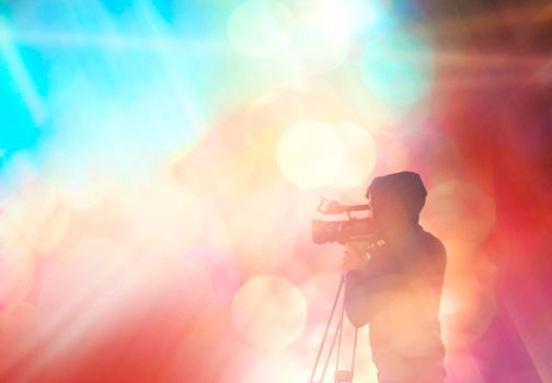 Abstract blurred background with the silhouette of a man. Videographer shoots on video camera.