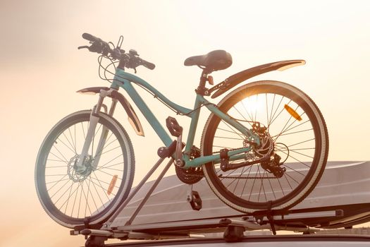 Bike and car trunk close up on sky background. Travelling by car