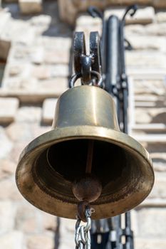 Bronze bell close-up on the wall background.